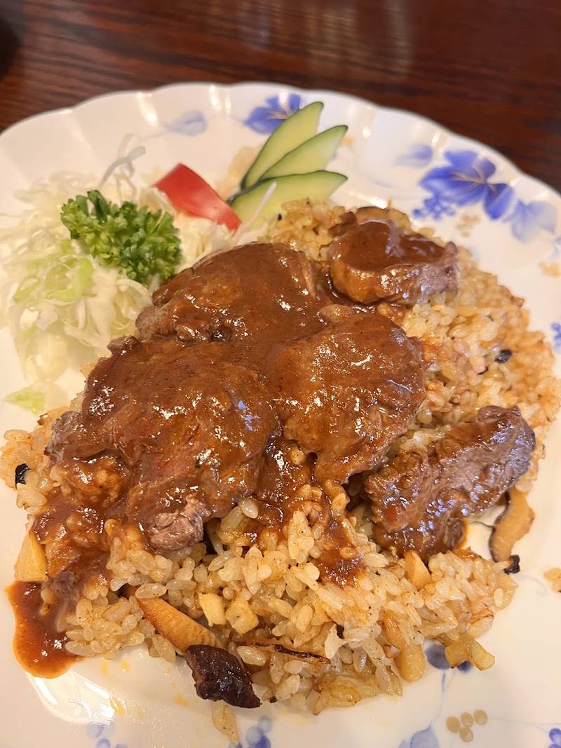 炒めたライスに肉をのせ、デミグラスソースをかけたどりあんの洋食の一皿